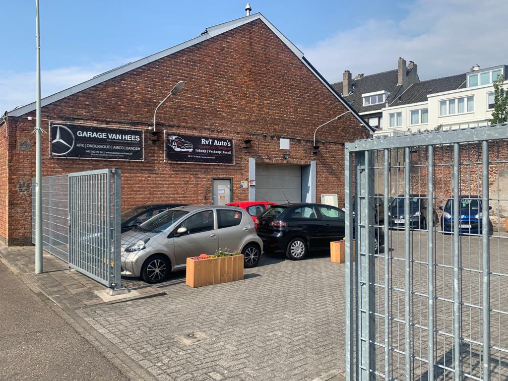 Het terrein van Garage van Hees met het hek open, in de zon